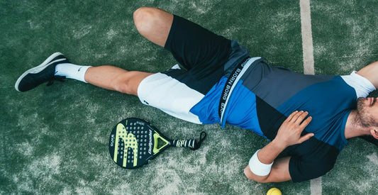 Man laying on the floor on a tennis court