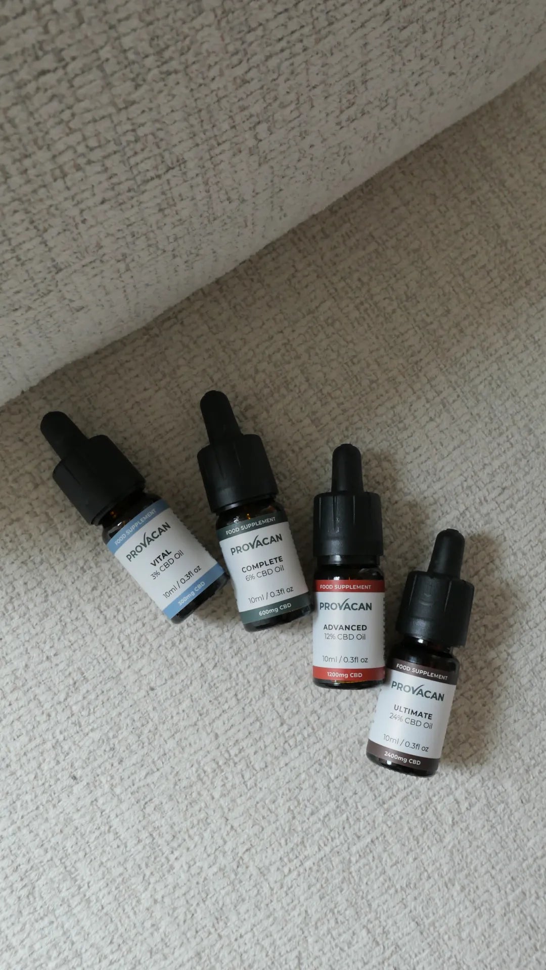 Full range of four Provacan CBD oil bottles on a couch