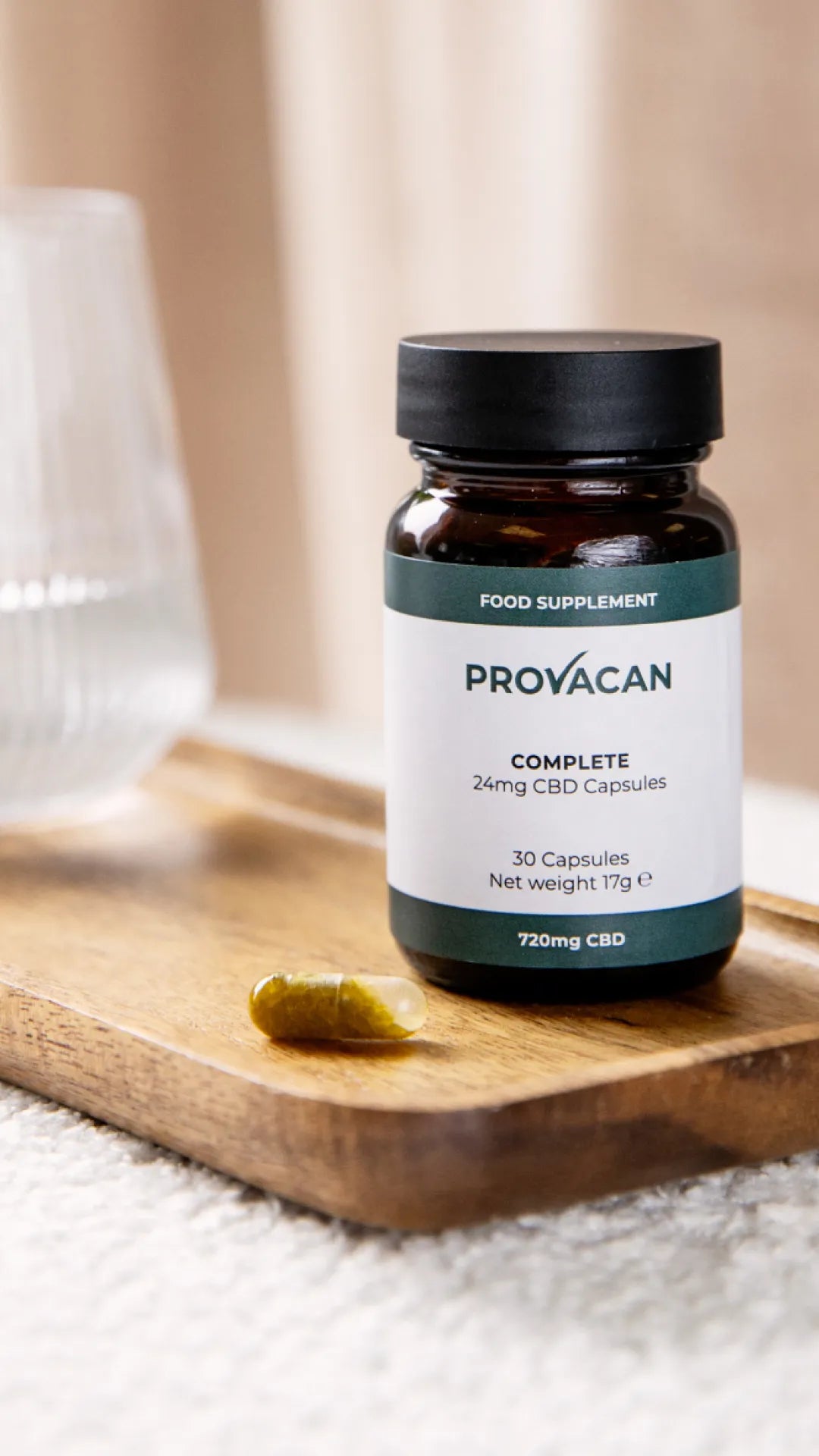 CBD capsules from Provacan: Complete 24mg CBD capsules on a wooden tray next to a glass of water