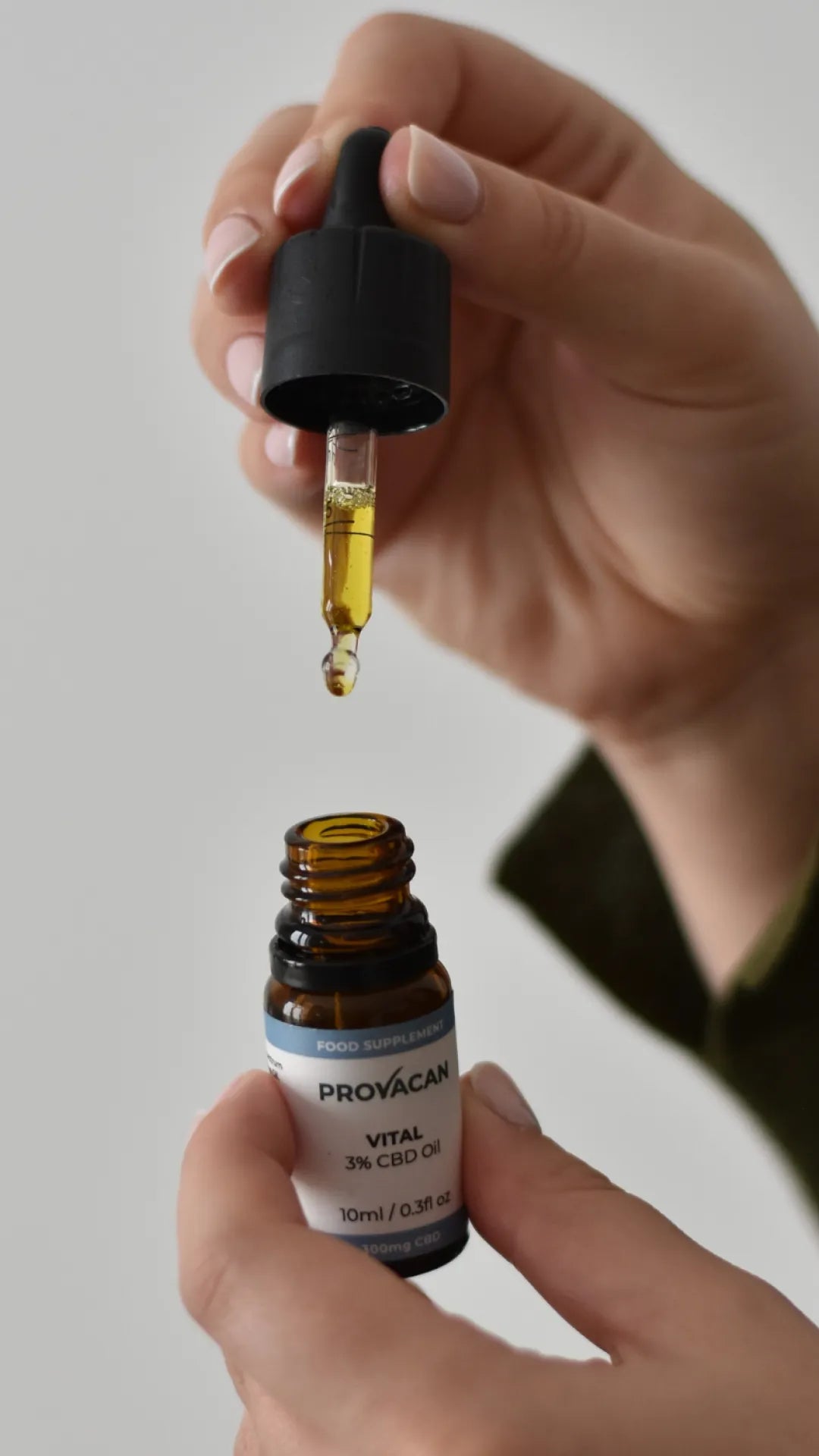 Provacan Vital 300mg / 3% CBD Oil bottle held in one hand and the oil dropper in another hand