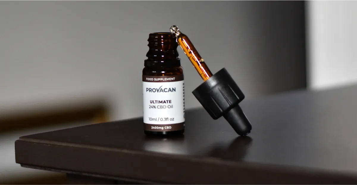 Provacan Ultimate 24% 2400mg CBD oil dropper bottle on a dark table with a blurred background