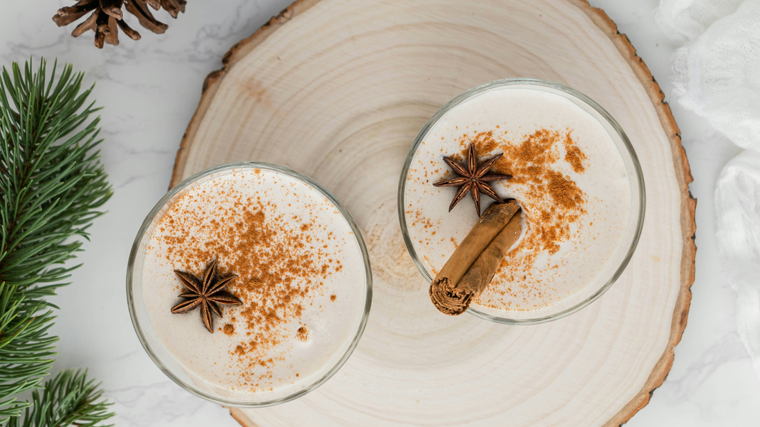 Two cups of winter drinks with cinnamon and anise on a Christmas festive table decor with wood