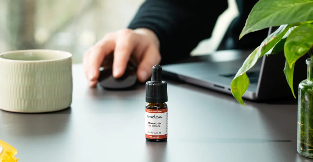 Provacan CBD oil for ADHD: Advanced 12mg CBD oil on a desk next to a laptop, a plant and a hand using a mouse