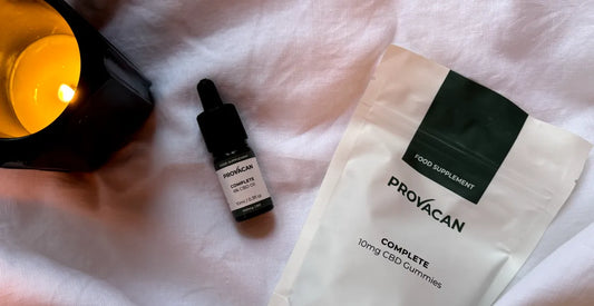 Provacan CBD for sleep: Provacan Complete 6% 600mg CBD Oil and Complete 10mg CBD Gummies on a bed with a candle next to them