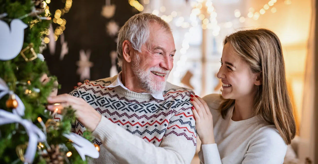 Man and woman smiling at each other near a decorated Christmas tree