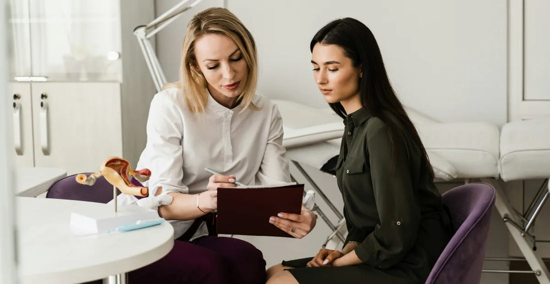 Two women in a medical consultation room reviewing a document