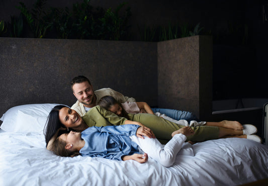 Family laughing on bed