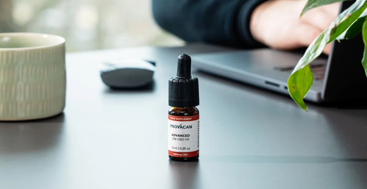 Bottle of medical cannabis oil on a desk with a blurred background