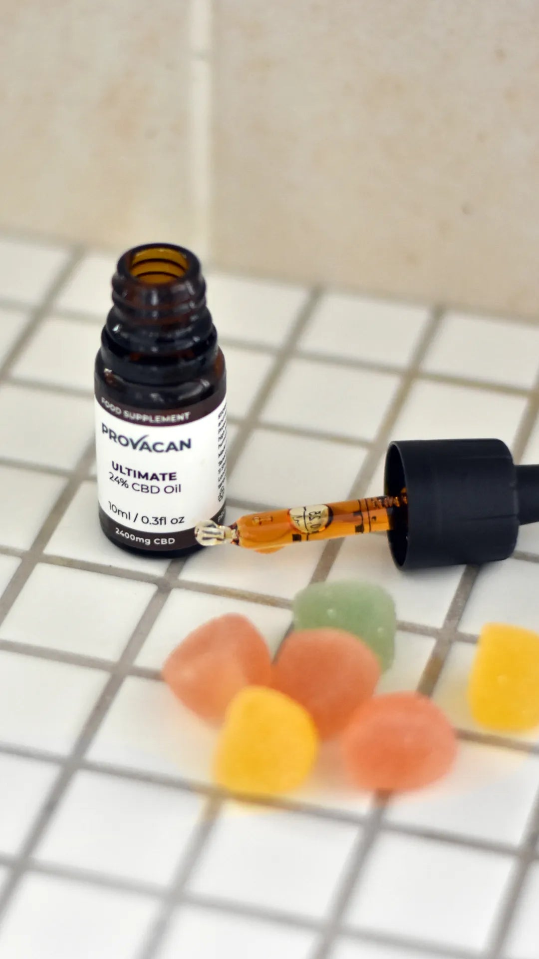 Provacan Bestsellers CBD Wellness Products: a few Complete 10mg CBD Gummies and Ultimate 24% 2400mg CBD oil bottle on white tiles