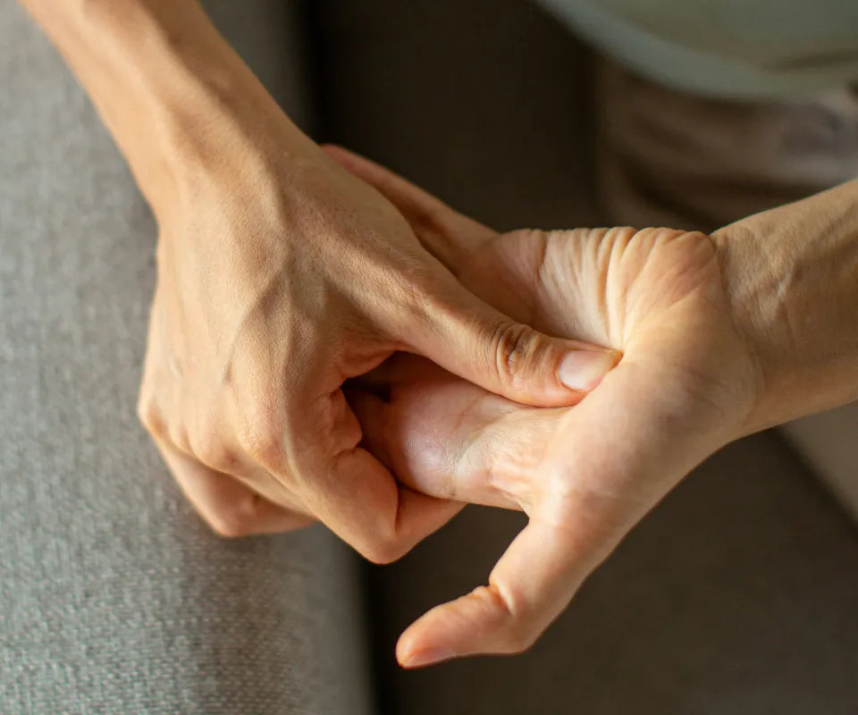 Close-up of a person’s hands as they use their thumb to massage the palm and base of their other hand