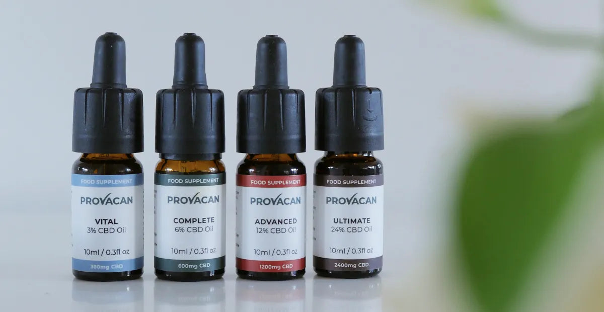 Close-up of CBD oil from Provacan: Vital 300mg CBD oil, Complete 600mg CBD oil, Advanced 1200mg CBD oil, Ultimate 2400mg CBD oil next to a blurred green leaf