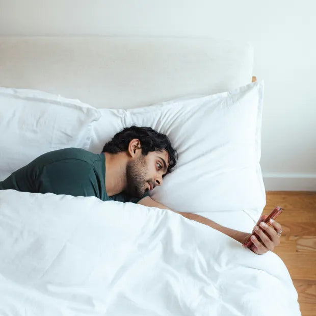 Man in bed on his phone