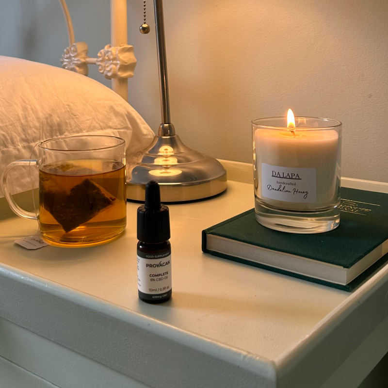 Provacan Complete CBD Oil 6% 600mg on a bedside table next to a tea and candle