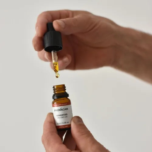 Hands holding Provacan Advanced 12% 1200mg CBD oil bottle and dropper