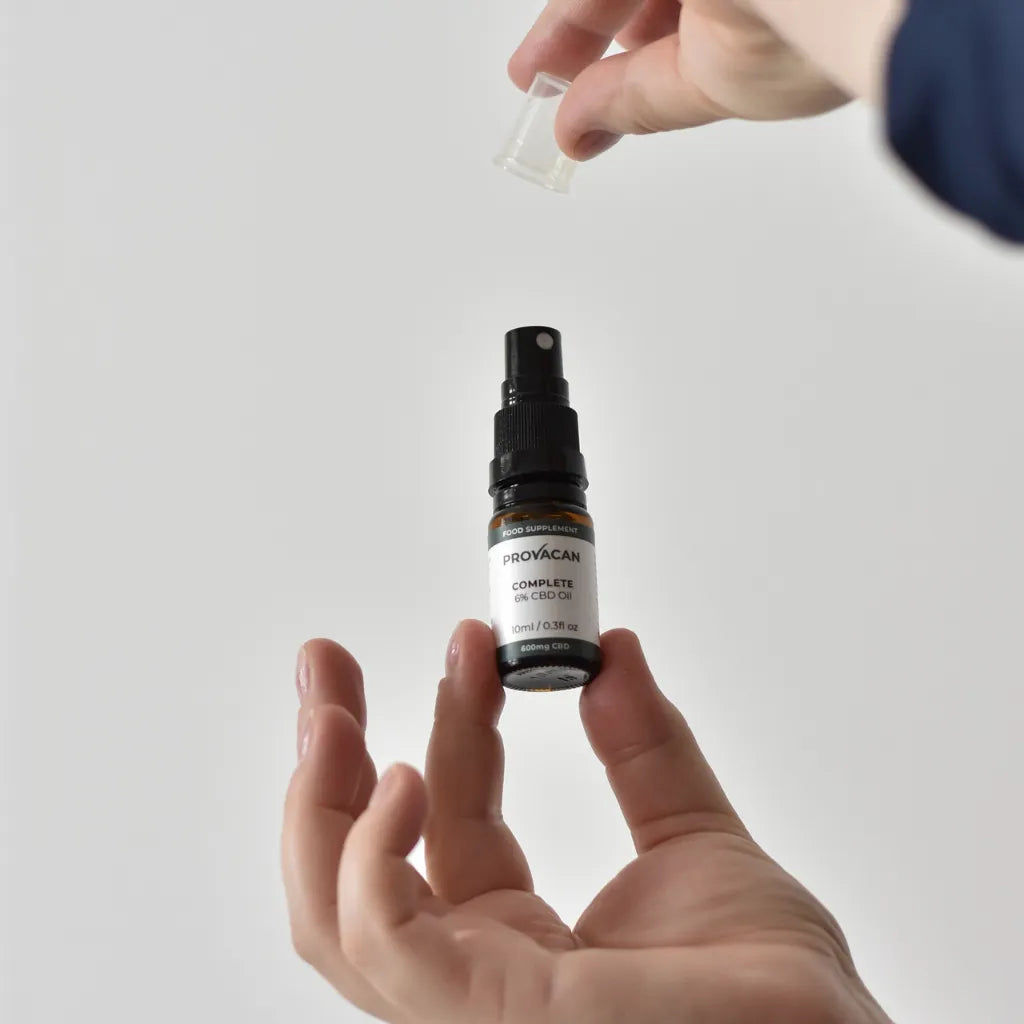 Person holding an open bottle of Provacan Complete 6% CBD Oil 