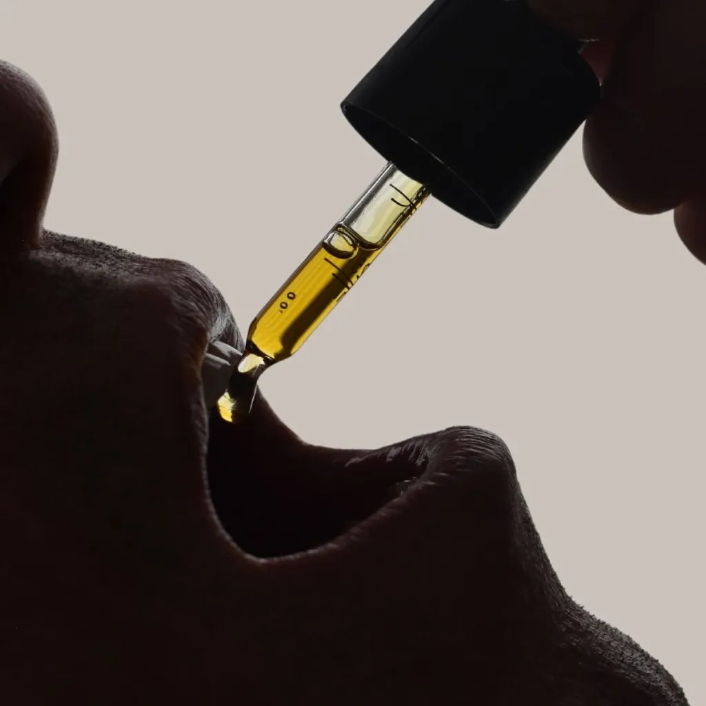 Close-up of person taking CBD oil drops 