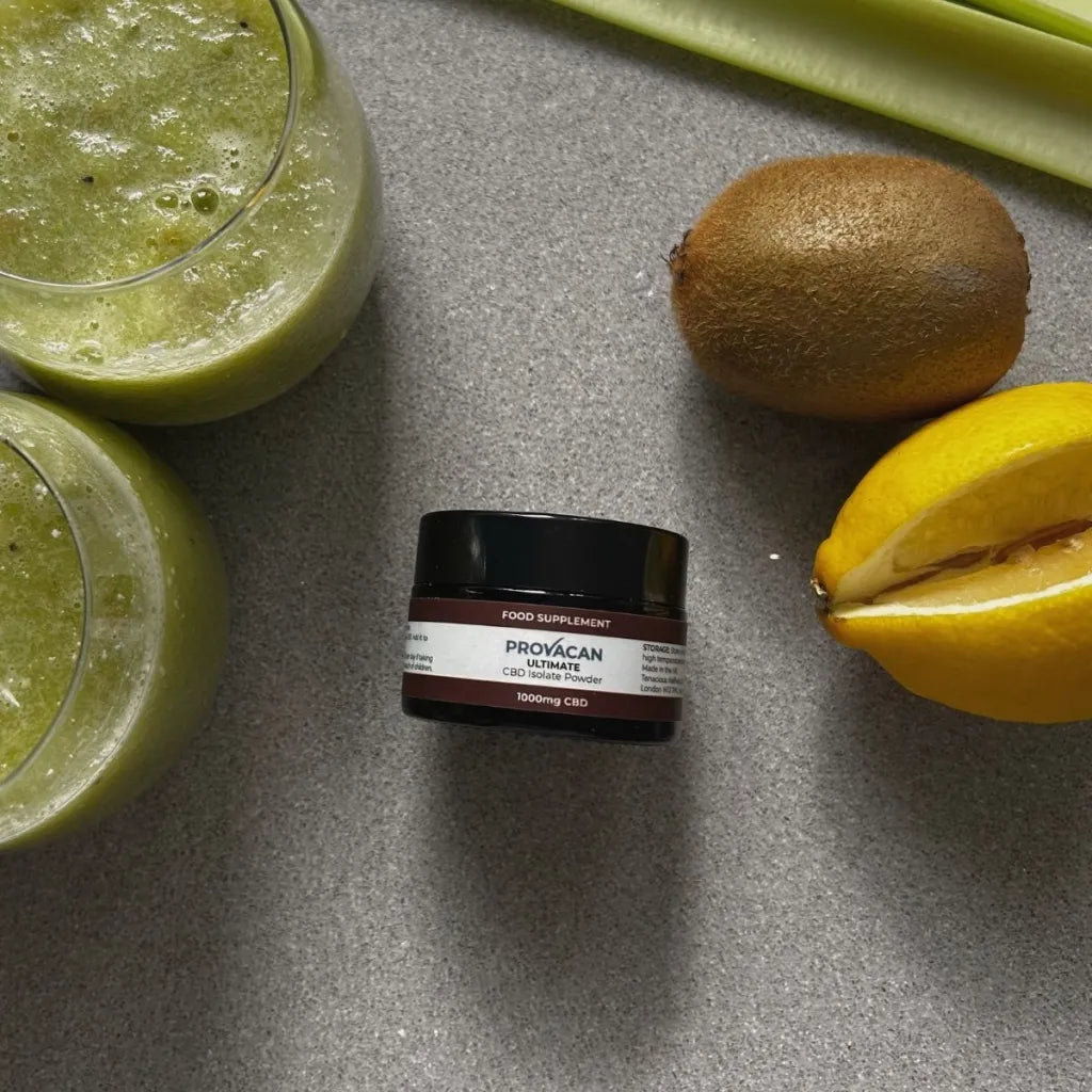 Jar of Provacan Ultimate CBD Isolate Powder 1000mg CBD on a kitchen surface surrounded by smoothies and fruits. 