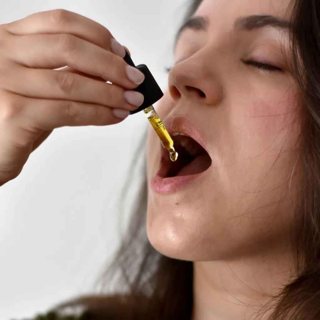 A woman taking Provacan CBD oil drops 